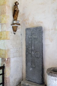 France, Cantal, Neussargues-Moissac, 12th century Saint-Hilaire church, tomb of a 17th century pilgrim who made the way to St Jacques de Compostela, tombstone with the bumblebee, the sack and the shell around the funeral cross