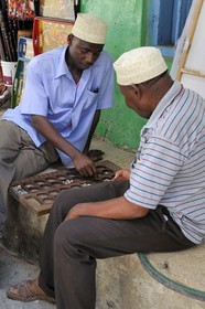 Tanzanie, archipel de Zanzibar, île de Unguja (Zanzibar), ville de Zanzibar, quartier Stone Town, classé Patrimoine Mondial de l' UNESCO, deux hommes entrain de jouer au jeu traditionnel d'Afrique l'Awale dans une ruelle de la vieille ville dans le quartier de Shangani