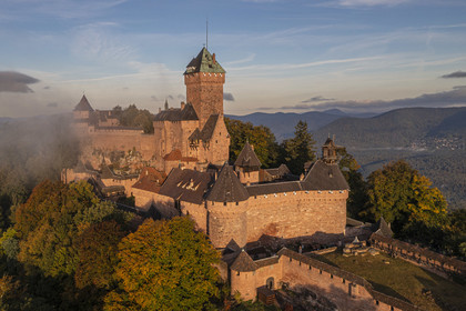 France, Bas Rhin, Orschwiller, Alsace Wine Road, the Haut Koenigsbourg Castle positioned on the Vosges foothills and overlooking the plain of Alsace to the east as well as the Villé and Bruche valleys to the west in the background (aerial view)