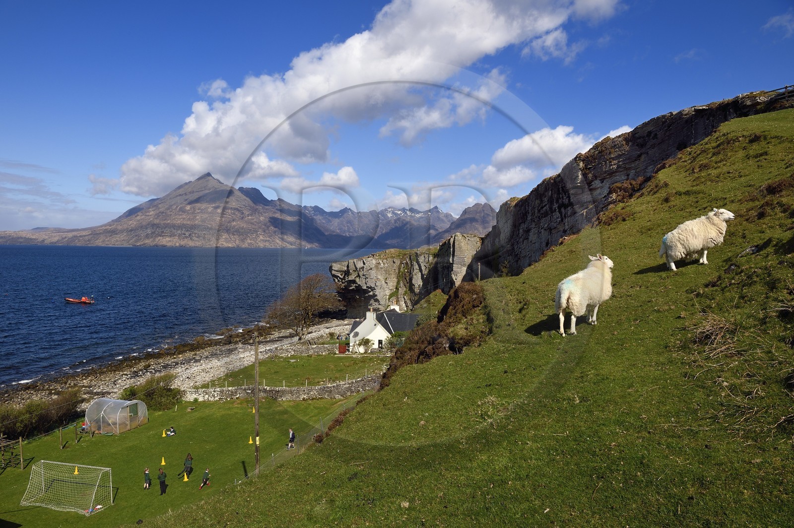 Royaume-Uni, Ecosse, région des Highlands, les Hébrides, Ile de Skye, village de Elgol sur les rives du Loch Scavaig au bout de la péninsule de Strathaird et le massif des Black Cuillin Mountains en arrière plan, enfants jouant au rounders dans le jardin de l'école