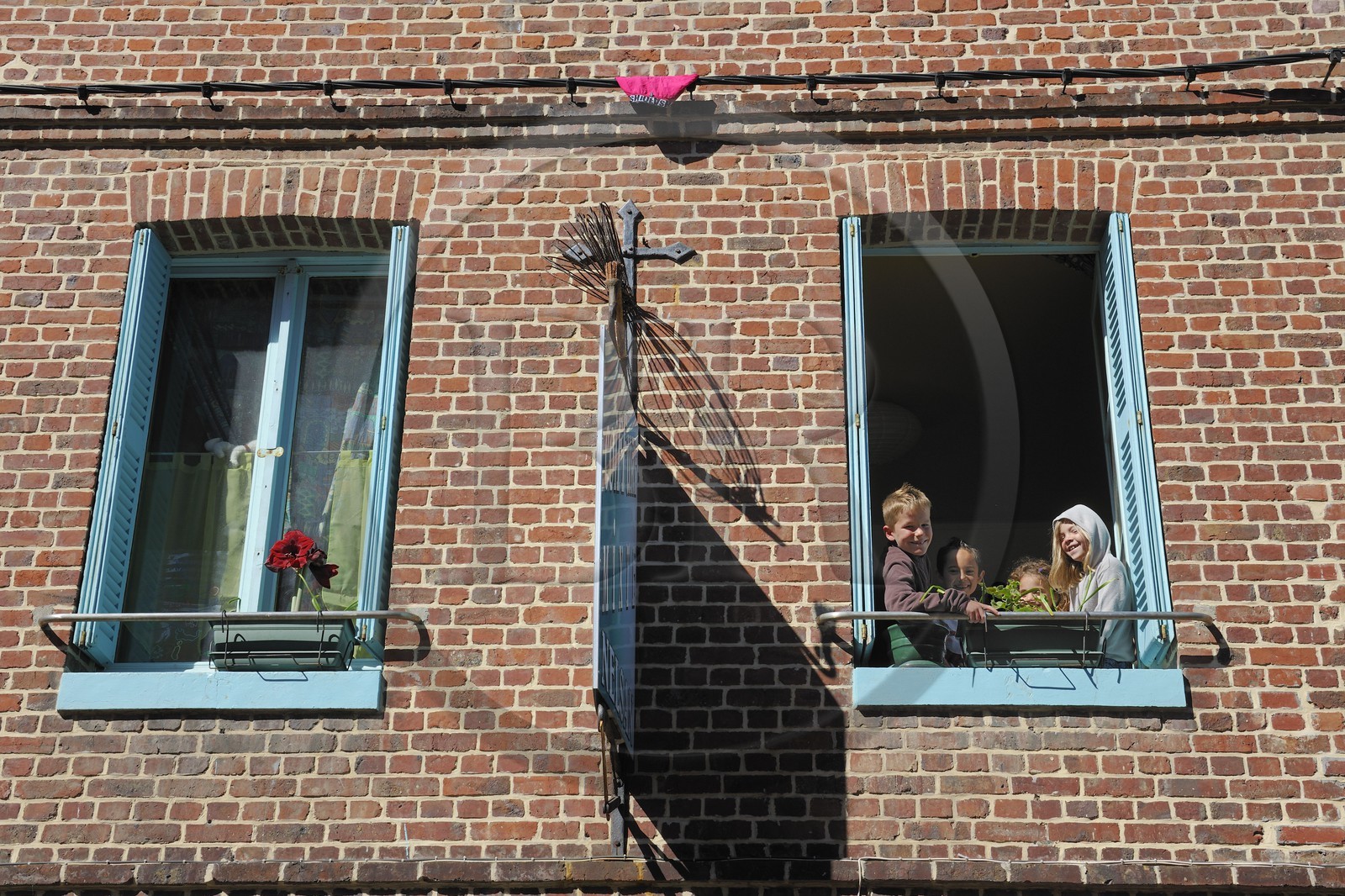 France, Seine-Maritime (76), Veules-les-Roses, enfants à la fenêtre d'un salon de coiffure