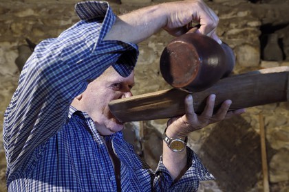 Georgia, Kakheti, Gurjaani, Velistsikhe, Mr Nordari, wine producer in his cellar, some traditionally drank wine in rounded boards