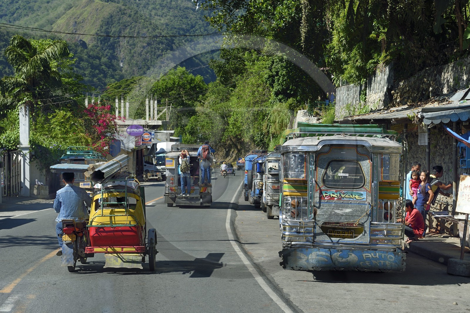 Philippines, province d'Ifugao, ville de Poblacion, jeepney (jeep allongée pour le transport de passagers) et tricycle moto-taxi dans la rue principale