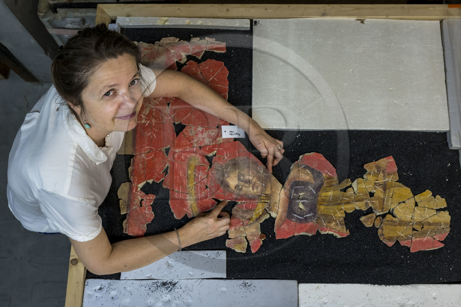 France, Bouches-du-Rhône (13), Arles, musée départemental Arles antique, dans les réserves du musée, issu des fouilles des ruines de la maison de la harpiste (entre 70 et 50 av. J.-C.) dans le site de l'ancienne verrerie de Trinquetaille sur la rive droite du Rhone, assemblage de fragments de la peinture murale à fresque adoptant du rouge vermillon avec le pigment le Cinabre le plus couteux du monde romain, la figure d’une harpiste qui a donnée son nom à la villa présentée par l'archéologue Marie-Pierre Rothé