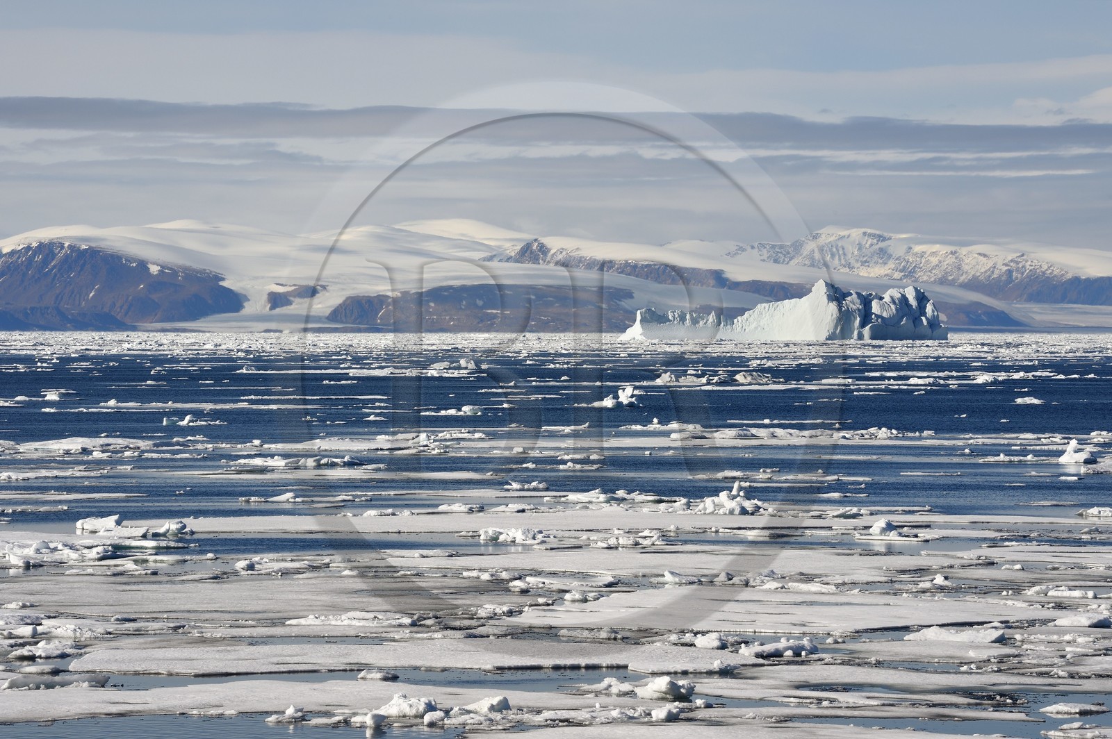 Groenland, cote Nord-Ouest, Smith sound au nord de la baie de Baffin, morceaux de glace de la banquise arctique et iceberg géant en arrière plan vers la côte canadienne de l'ile d'Ellesmere