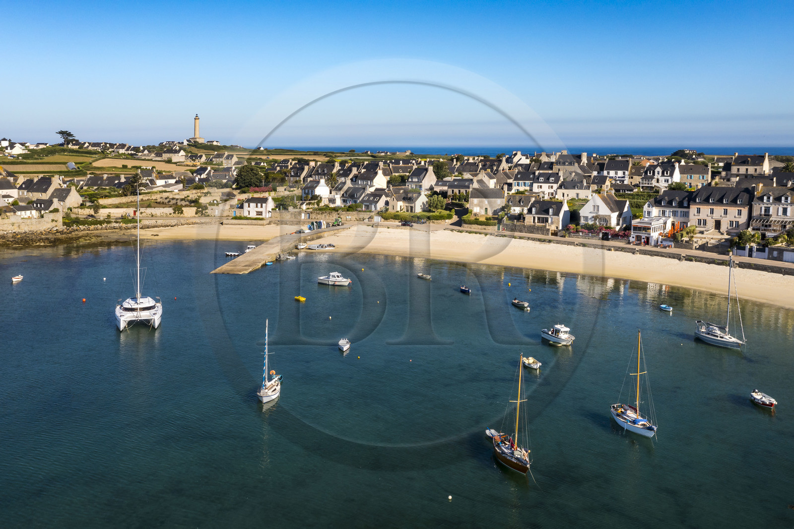France, Finistère, Ponant Islands, Ile de Batz (Batz Island), the village on the edge of the bay of Porz-Kernok and the lighthouse in the background (aerial view)