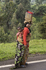 Rwanda, Province de l’Ouest, Mwaga, femme transportant son enfant dans le dos et portant son sac sur la tête