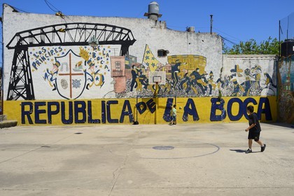 Argentina, Buenos Aires, La Boca district, child playing football in a playground