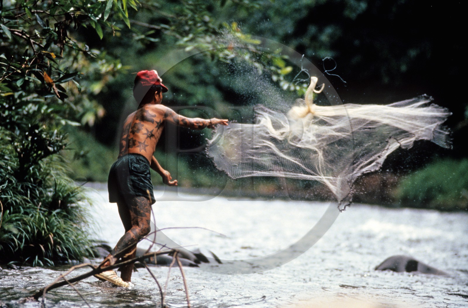 Malaisie, île de Bornéo, Sarawak, un Iban pêche au filet dans la rivière Engkari Malaisie, île de Bornéo, Sarawak, un Iban pêche au filet dans la rivière Engkari