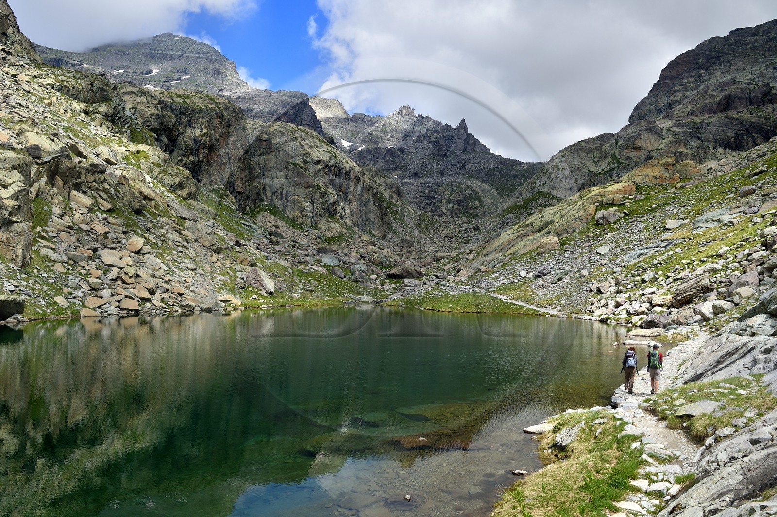 France, Alpes-Maritimes (06), parc national du Mercantour, Vallée des Merveilles parsemée de milliers de gravures rupestres de l'Age de bronze, randonneurs sur le sentier de randonnée GR 52 au lac des Merveilles en contrebas de la Baisse de Valmasque et le Mont du Grand Capelet (2915m) en arrière plan à gauche