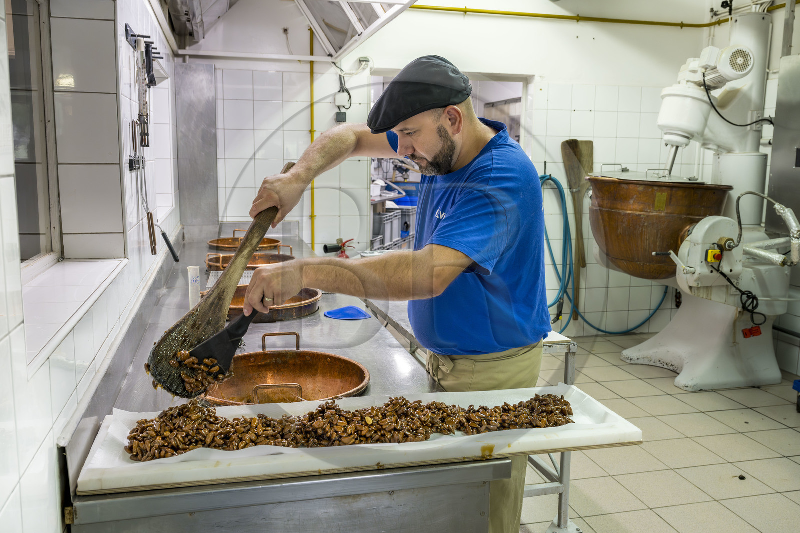 France, Vaucluse (84), Saint Didier, dans l'atelier de fabrication des Nougats Silvain, paysans nougatiers, Charles-Henri Bagnol confectionne une plaque de nougat noir avec les amandons grillés et le miel France, Vaucluse (84), Saint Didier, dans l'atelier de fabrication des Nougats Silvain, paysans nougatiers, Charles-Henri Bagnol confectionne une plaque de nougat noir avec les amandons grillés et le miel