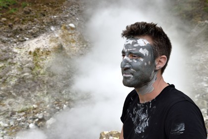 Caraïbes, Ile de la Dominique, Castle Bruce, Parc national du Morne Trois Pitons classé Patrimoine Mondial de l'UNESCO, la Vallée de la Désolation, randonneur sur le sentier menant au Boiling Lake avec un masque de boue de la une rivière aux sources d'eau chaude dont la couleur unique est due à la présence de calcium, de carbone, de soufre et de fer