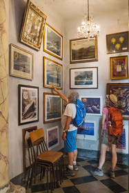 Italy, Liguria, Cinque Terre National Park listed as World Heritage by UNESCO, hikers observing the Ex-Voto in the church of the sanctuary of Nostra Signora di Reggio on the heights of the village of Vernazza
