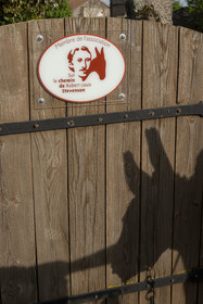 France, Haute-Loire (43), Bouchet-Saint-Nicolas, hiking with a donkey on the Robert Louis Stevenson Trail (GR 70), sign indicating a member of the Chemin de Stevenson association and projected shadow of the donkey Anatole