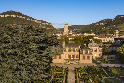 France, Aveyron, the Mansion of Sambucy De Sorgues and its French gardens, the belfry in the heart of the city and et the Puncho d'Agast mountain in the background, a 180 year old Atlas cedar (Cedrus atlantica) on the left (aerial view)