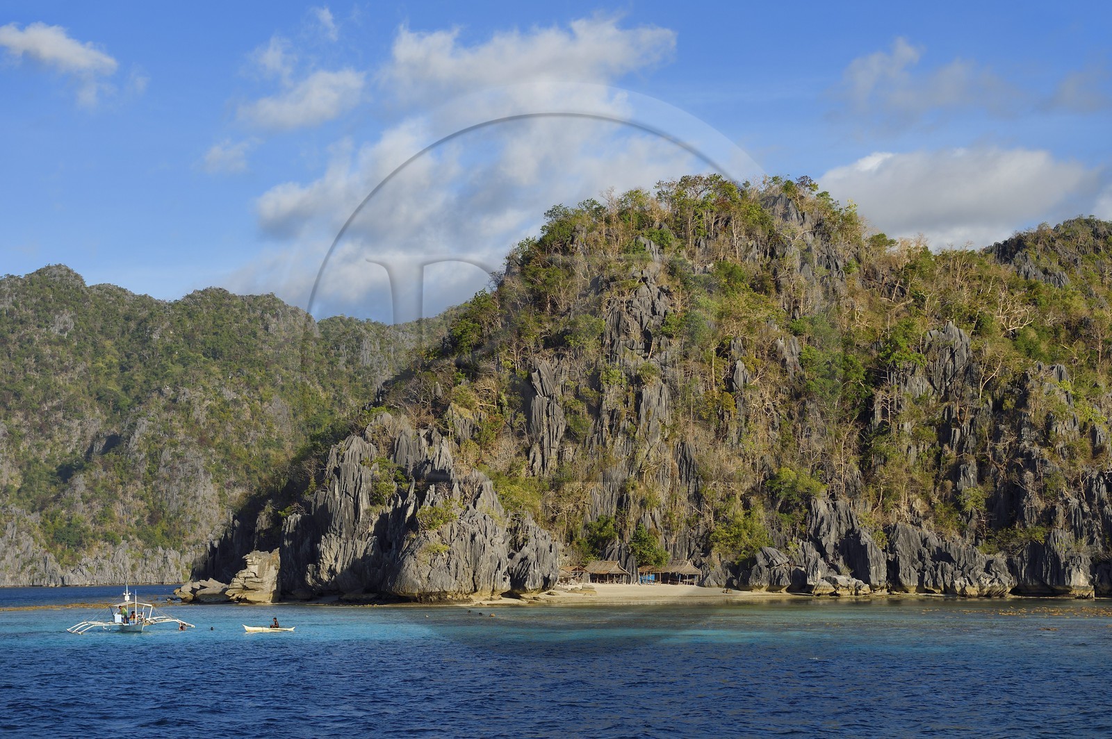 Philippines, Calamian Islands in northern Palawan, Coron Island Natural Biotic Area, Banul Beach under walls of limestone cliffs