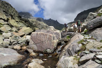 France, Alpes-Maritimes, parc national du Mercantour (Mercantour National Park), the Vallee des Merveilles (Valley of Wonders) scattered with thousands of rupestral engravings of the Bronze Age, hikers on the trail GR 52 towards the Baisse (pass) de Valmasque and the Mont Grand Capelet (2915 m) in the background