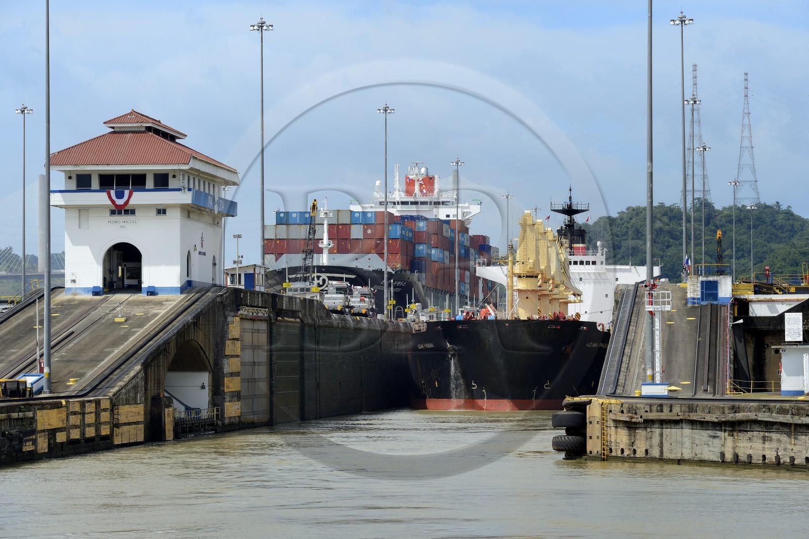 Panama, Canal de Panama, écluses de Pedro Miguel, mules mécaniques ou locomotives électriques guidant un cargo Panamax entre les murs de l'écluse