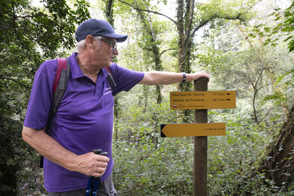 France, Yonne, the valley of the Cousin river between Pontaubert and Avallon, Hervé Desruelles, retired farmer and head of the Terre de Légendes hiking club, passing in front of the sign for the GR 213 from Vézelay to Fontenay Abbey