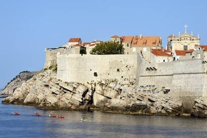 Croatia, Dalmatia, Dalmatian coast, Dubrovnik, Historic Centre listed as World Heritage by UNESCO, kayaks passing at the foot of the ramparts on the sea side and the Church of Saint Ignatius in the background