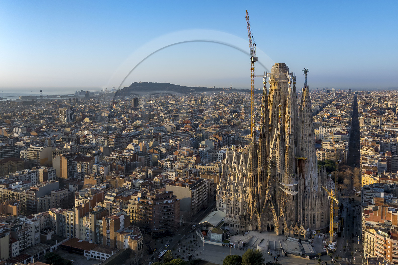 Espagne, Catalogne, Barcelone, quartier de l'Eixample, basilique de la Sagrada Familia de l'architecte du modernisme catalan Antoni Gaudi classée Patrimoine Mondial de l'UNESCO, façade de la Nativité, le port et la colline de Montjuic en arrière plan