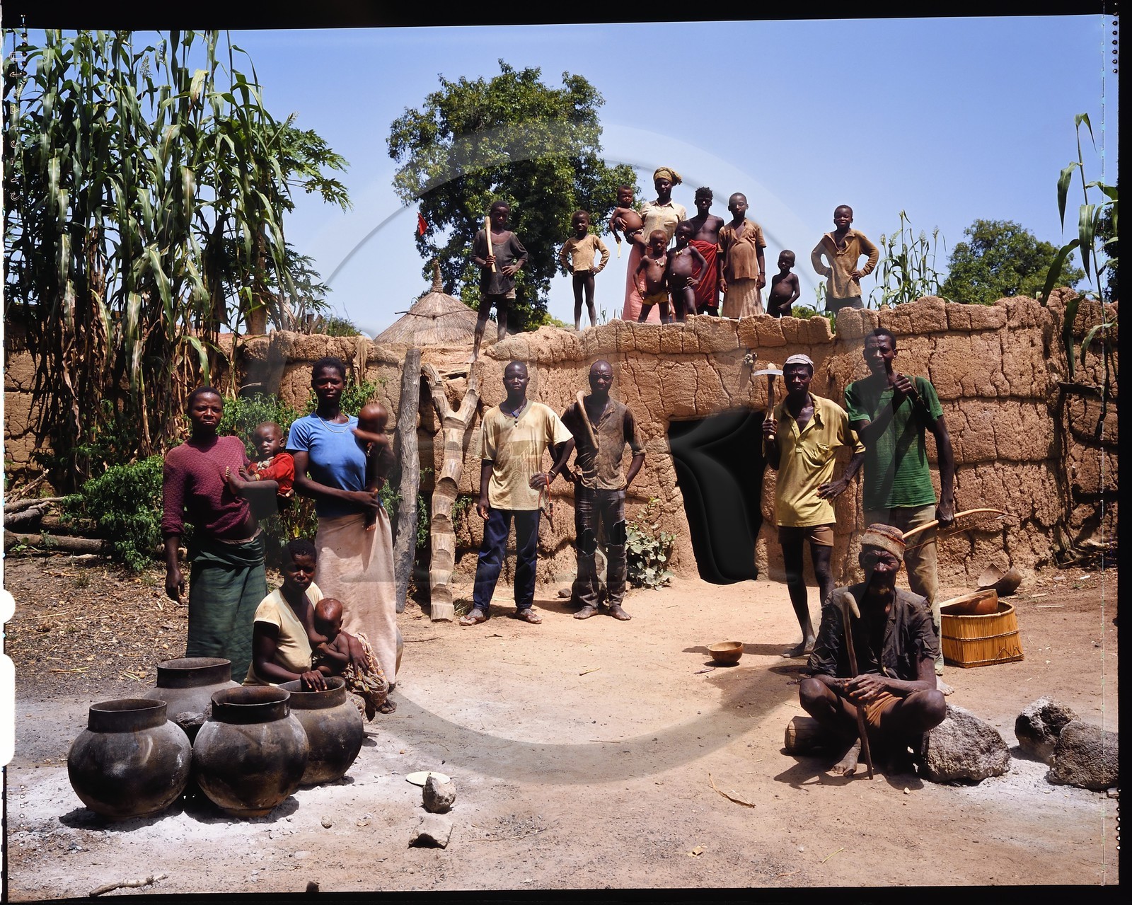 Burkina Faso, province de Poni, pays des Lobi, Loropéni, paysans posant avec la houe dans la cour de ferme devant la maison principale