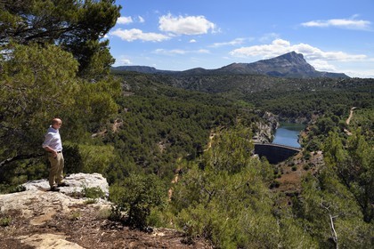 France, Bouches-du-Rhône (13), Aix en Provence, plateau de Bibemus, randonnée du GR 2013, le barrage Zola ( Cézanne y a peint la série des Baigneurs) et la montagne Sainte Victoire en arrière plan, au premier plan Michel Fraisset, directeur des sites de Cézanne à Aix-en-Provence et de l’Office du tourisme