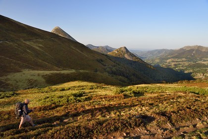 France, Cantal, Parc Naturel Régional des Volcans d'Auvergne (regional nature park of Auvergne volcanoes), Le Lioran, col de Rombiere (mountain pass) overlooking the Jordanne valley, hikers on the Way of St. James to Santiago de Compostela by Via Arverna, in the background the Puy Griou emerging on the left and the Griounou on its right
