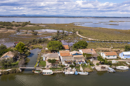 France, Hérault (34), La Grande-Motte, lieu dit des Cabanes du Roc, anciennes cabanes de pécheurs en bordure du canal du Rhône à Sète, l'étang de l'Or en arrière plan (vue aérienne)