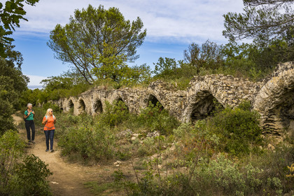 France, Gard (30), Vers-Pont-du-Gard, randonneurs longeant les vestiges de l'aqueduc romain de plus de 52 km de longueur qui amenait l'eau de la Fontaine d'Eure au pied d'Uzès jusqu'à Nimes en passant sur le Pont du Gard