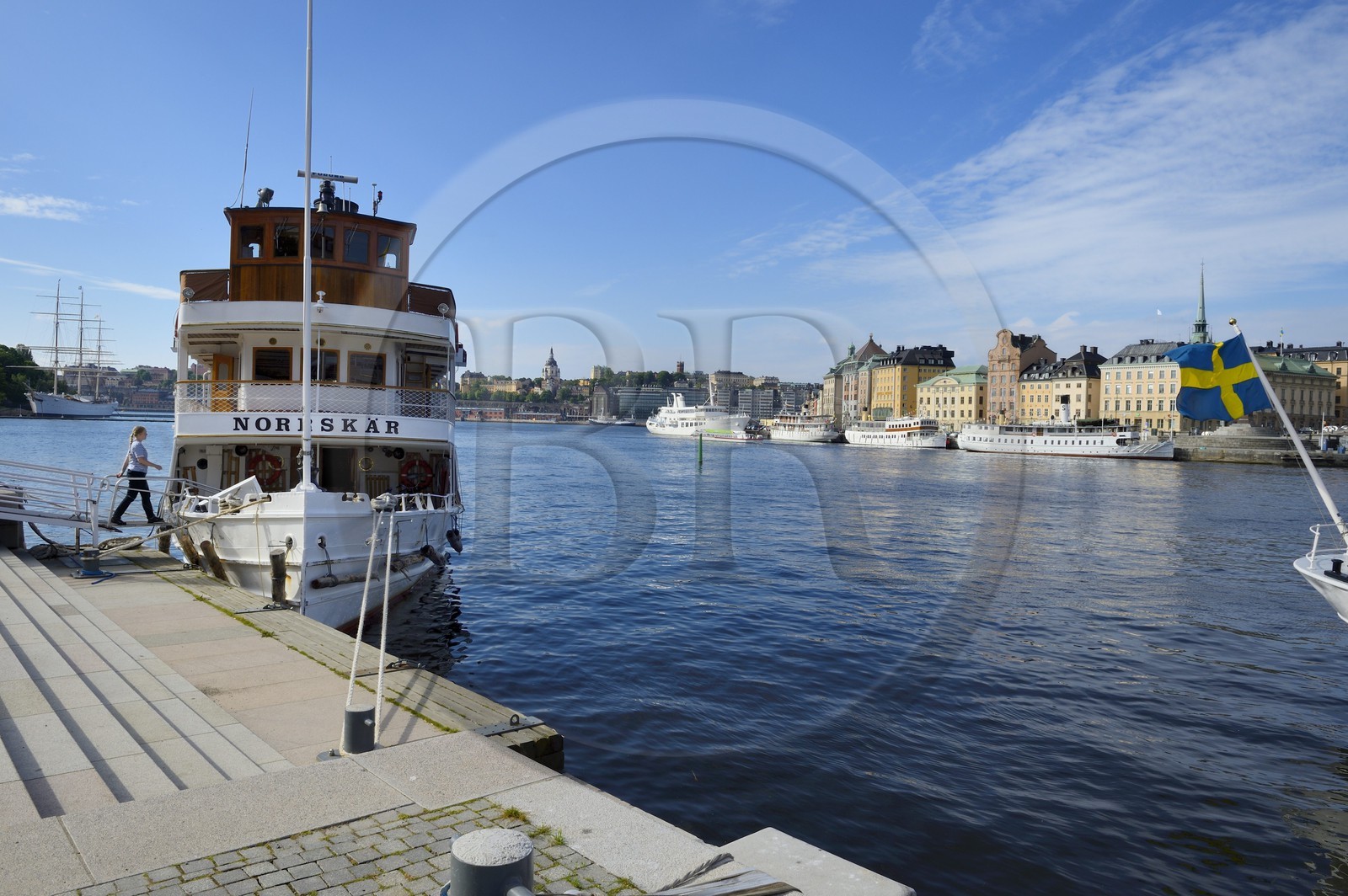 Sweden, Stockholm, the old city on the island of Gamla stan seen from the Nationalmuseum, a ferry docked in the foreground