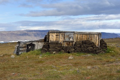 Groenland, cote ouest, Baie de North Star, Wolstenholme fjord, Dundas (Thulé), Igloo inuit, maison traditionnelle avec murs en tourbe et à partir du début du XXe siècle aussi une structure interne en bois, la calotte glaciaire en arrière plan