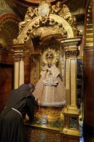 Spain, Extremadura, Guadalupe, Royal Monastery of Santa Maria de Guadalupe listed as World Heritage by UNESCO, monk in front of the Virgin throne in the Camarin