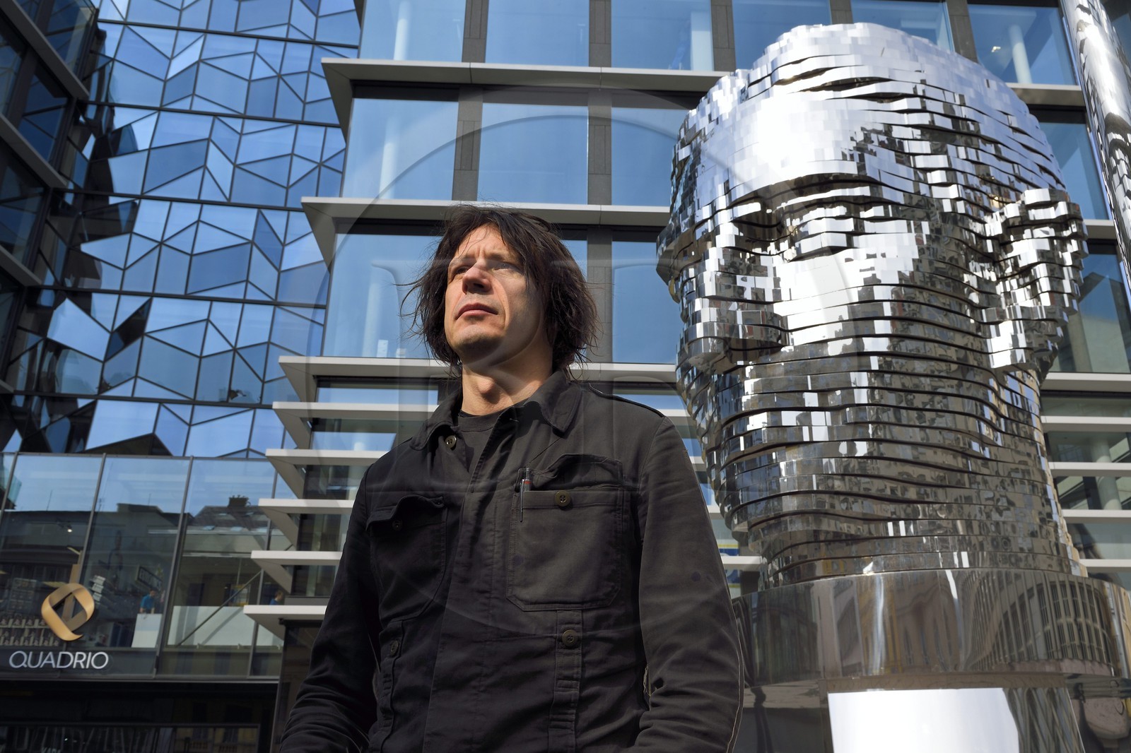 Czech Republic, Prague, Nove Mesto, artist David Cerny posing in front of his work Franz Kafka head, a mechanical statue