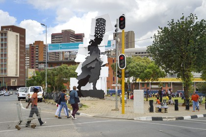 South Africa, Gauteng Province, Johannesburg, CBD (Central Business District), the Fire Walker sculpture by William Kentridge and Gerhard Marx represents a woman carrying a brazier on her head in commemoration of the activity which took place in the area in recent years, when ladies would prepare and sell their fires to others preparing food
