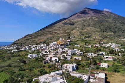 Italie, Sicile, iles Eoliennes, classées Patrimoine Mondial de l'UNESCO, ile de Stromboli, le village dominé par le volcan actif du Stromboli en arrière plan (vue aérienne)