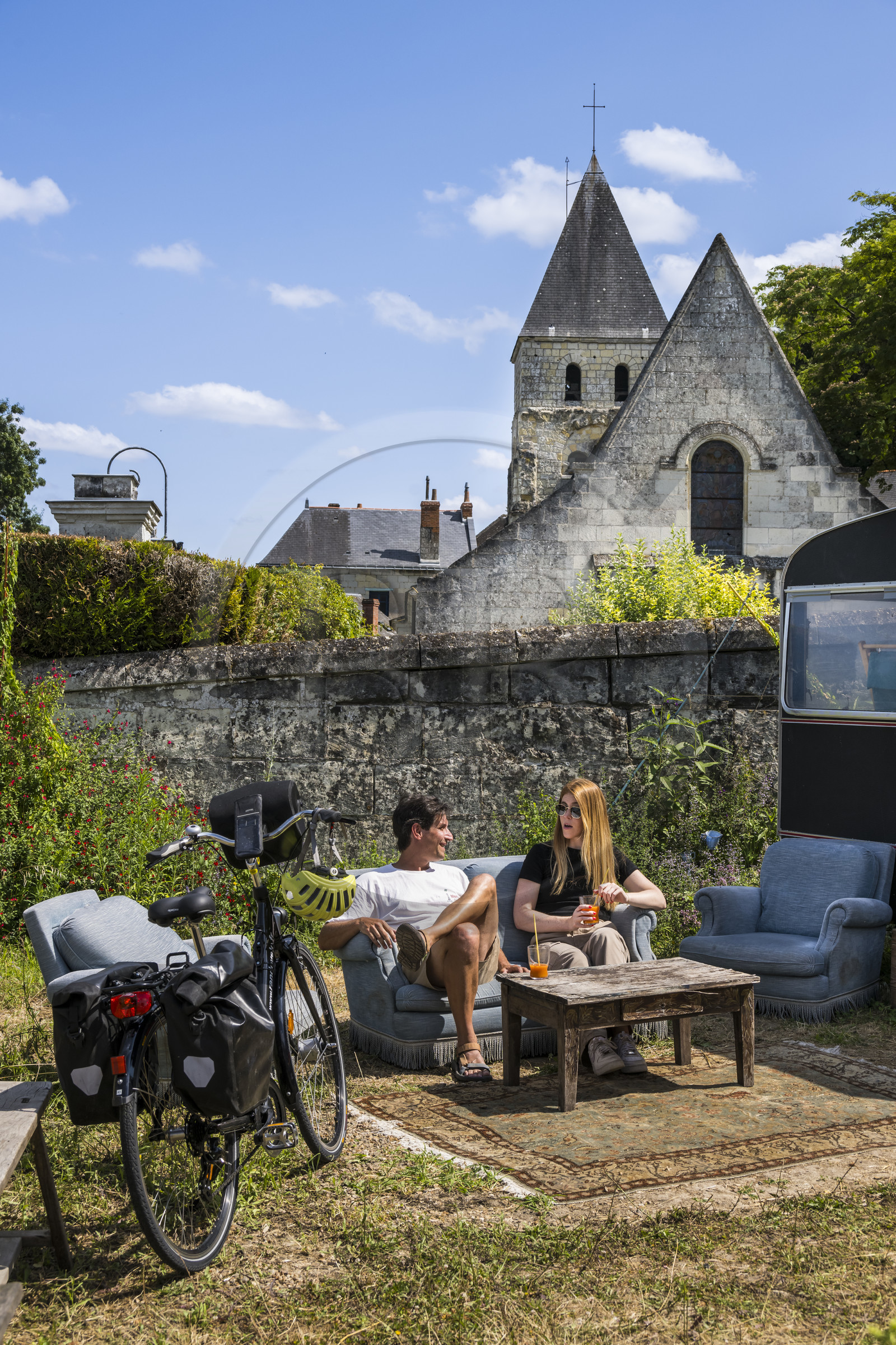 France, Maine-et-Loire (49), vallée de la Loire classée au Patrimoine Mondial par l'UNESCO, Gennes-Val-de-Loire, randonnée à bicyclette sur les berges de la Loire, pause à la librairie-café L'Idiot de l'association Gabare And Co dans l'ancienne école des Filles de Chênehutte, l'église notre dame des tuffeaux en arrière plan France, Maine-et-Loire (49), vallée de la Loire classée au Patrimoine Mondial par l'UNESCO, Gennes-Val-de-Loire, randonnée à bicyclette sur les berges de la Loire, pause à la librairie-café L'Idiot de l'association Gabare And Co dans l'ancienne école des Filles de Chênehutte, l'église notre dame des tuffeaux en arrière plan