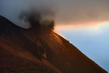 Italie, Sicile, iles Eoliennes, classées Patrimoine Mondial de l'UNESCO, ile de Stromboli, éruption et projection de bombes de lave sur les pentes du volcan actif au coucher de soleil