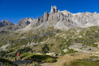 France, Hautes Alpes (05), le Briançonnais, Névache, randonneuse dans la vallée de la Clarée, le massif des Cerces et les pointes de la Main de Crépin (2942m) en arrière-plan