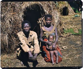 Burundi, Muyinga Province, Twa (pygmy) family in front of their straw hut, you can see the fingers of the young mother already distorted by the pottery work, Twa like most other African Pygmy groups have always been pushed further into the forests by other ethnicities, the fact that Burundi have almost no primary forests anymore leads them to live very poorly in the remotest parts of the country in small village structures made of straw huts (4x5 reversal film reproduction)