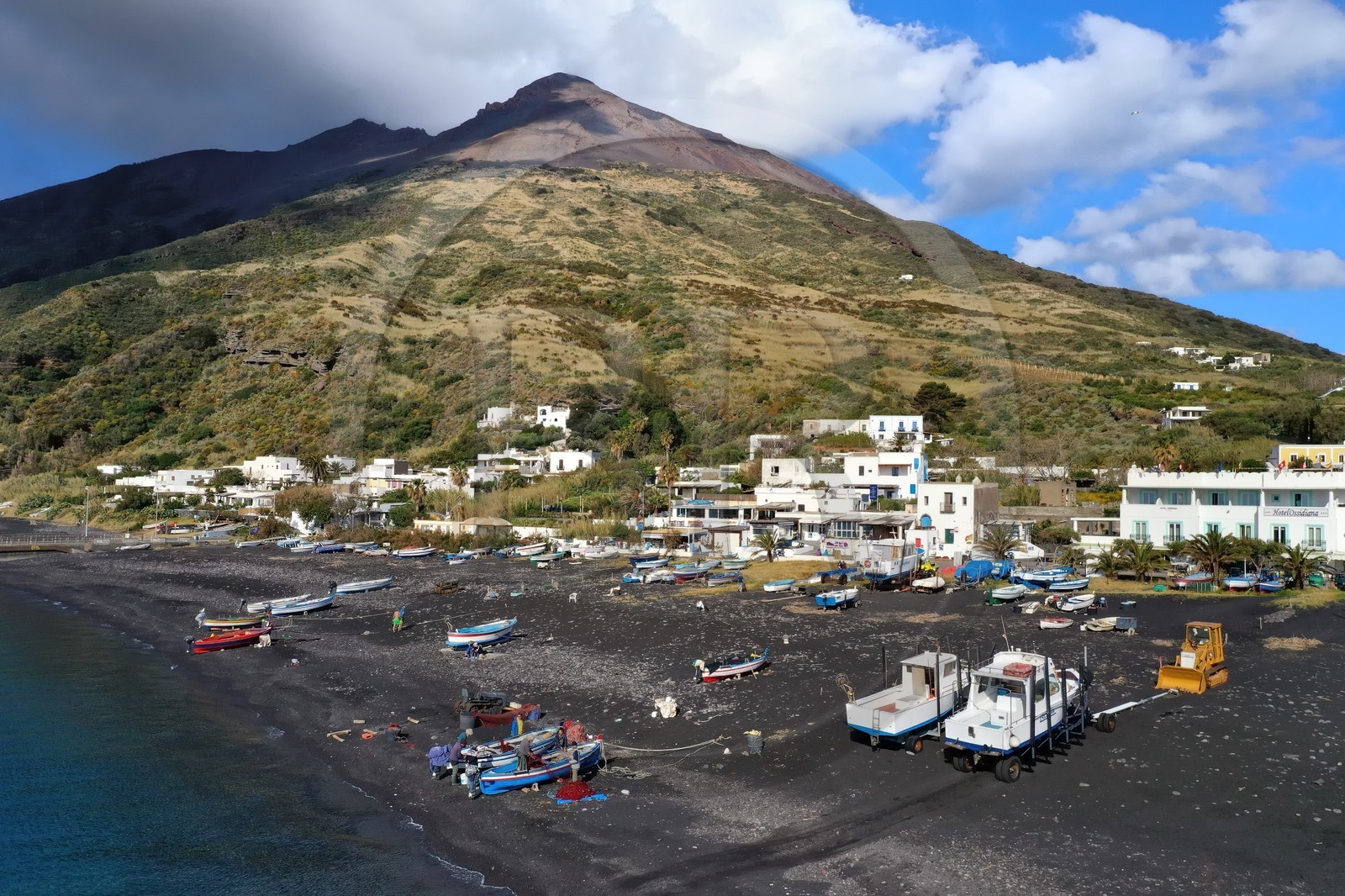 Italie, Sicile, iles Eoliennes, classées Patrimoine Mondial de l'UNESCO, ile de Stromboli, pecheurs sur la plage de Scari et le volcan actif du Stromboli en arrière plan (vue aérienne)