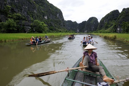 Vietnam, Ninh Binh province nicknamed Inland Halong Bay, small boat trip in Tam Coc surrounded by karstic moutains, rowing with her feet