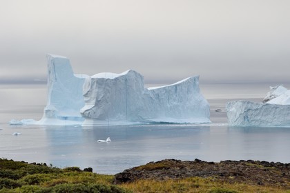 Greenland, west coast, Disko Island, Qeqertarsuaq, boat between two icebergs along the coast