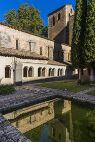 France, Herault, the Causses and the Cevennes, Mediterranean agro pastoral cultural landscape, listed as World Heritage by UNESCO, Saint Guilhem le Desert, labelled Les Plus Beaux Villages de France (The Most Beautiful Villages of France), the 9th century Gellone abbey, the cloister with its fishpond in the foreground