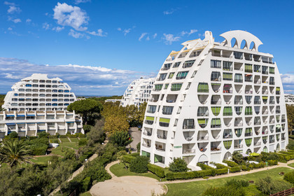 France, Herault, La Grande-Motte, labeled 20th century heritage, Couchant (setting sun) district west of the port, Le Poseidon building by architects Gilles and Jean Balladur in the foreground (aerial view)