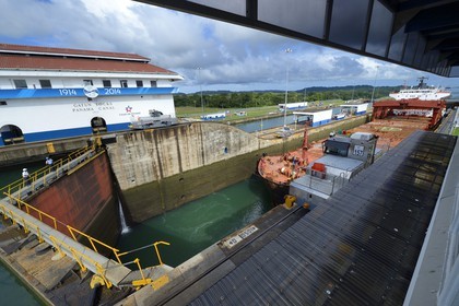 Panama, Colon province, Panama Canal, Gatun locks, mechanical mules or electric locomotives guiding a Panamax cargo between the lock walls
