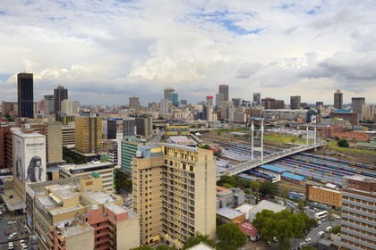South Africa, Gauteng Province, Johannesburg, Nelson Mandela bridge over train carriages at Park Station and Johannesburg CBD (Central Business District) seen from the district of Braamfontein