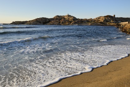 France, Haute Corse, Balagne, L'Ile Rousse, the Pietra Lighthouse and the fifteenth century Genoese tower behind the beach