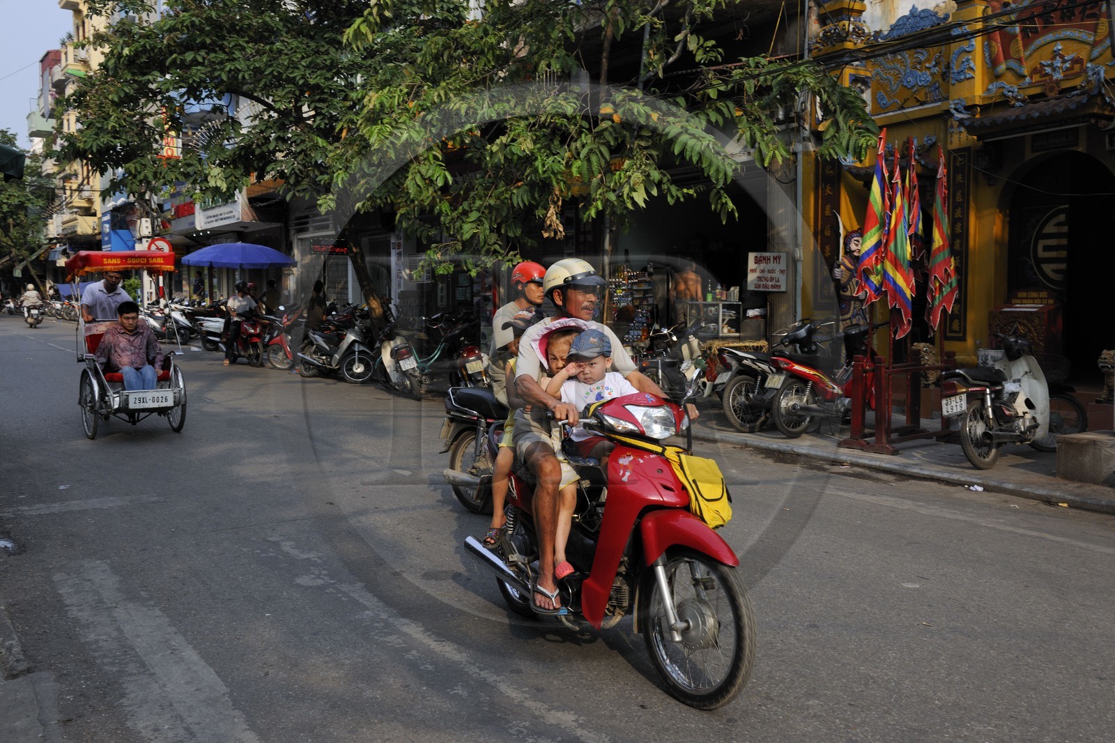 Vietnam, Hanoï, circulation d'une famille sans casque en moto dans la vieille ville