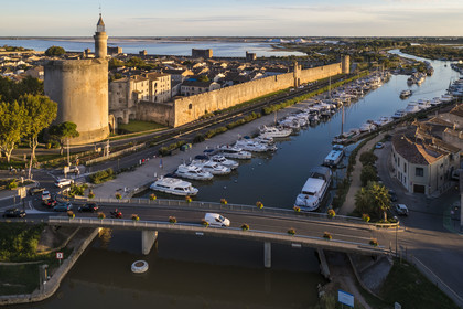 France, Gard (30), Aigues-Mortes, la ville médiévale entourée par ses remparts, la Tour de Constance et le port du canal du Rhône à Sète au premier plan, les marais salants (Salins du Midi) en arrière plan (vue aérienne)